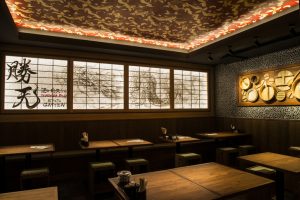 肉天ぷら、寿司、刺身などの和食とともに厳選地酒が楽しめる「酒と肉天ぷら 勝天-KYOTO GATTEN- 先斗町本店」の店内にテーブル席の写真