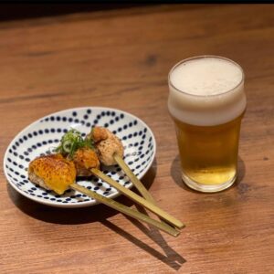 肉天ぷら、寿司、刺身などの和食とともに厳選地酒が楽しめる［酒と肉天ぷら 勝天-KYOTO GATTEN- 先斗町本店］で提供するつくねとビールのイメージ写真